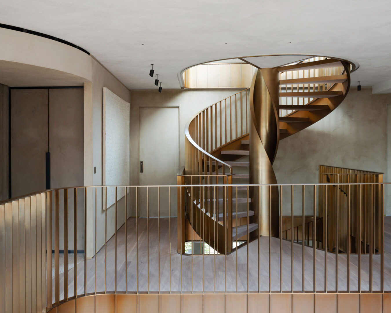 Brass spiral staircase with railing in modern home.