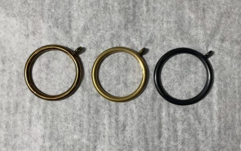 Three round metal curtain rings.