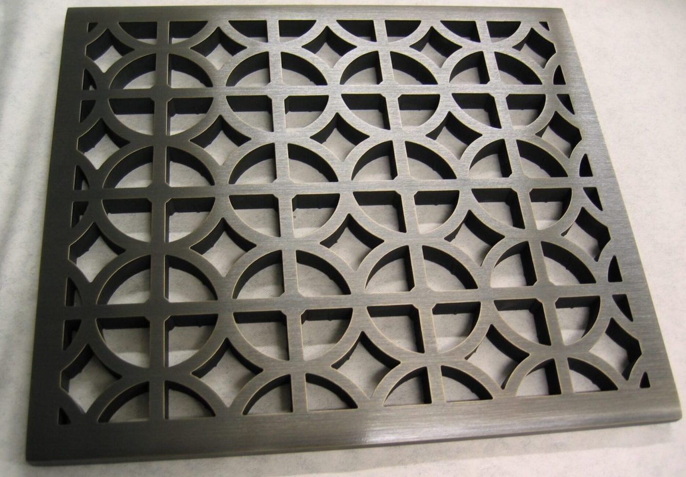 Metal grille with circular cutouts.